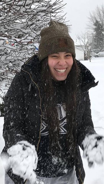 Uma mulher feliz brincando na neve